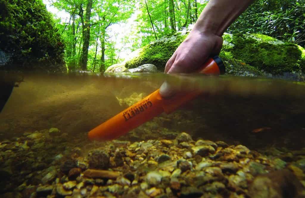 Man using Pinpointers metal detector underwater